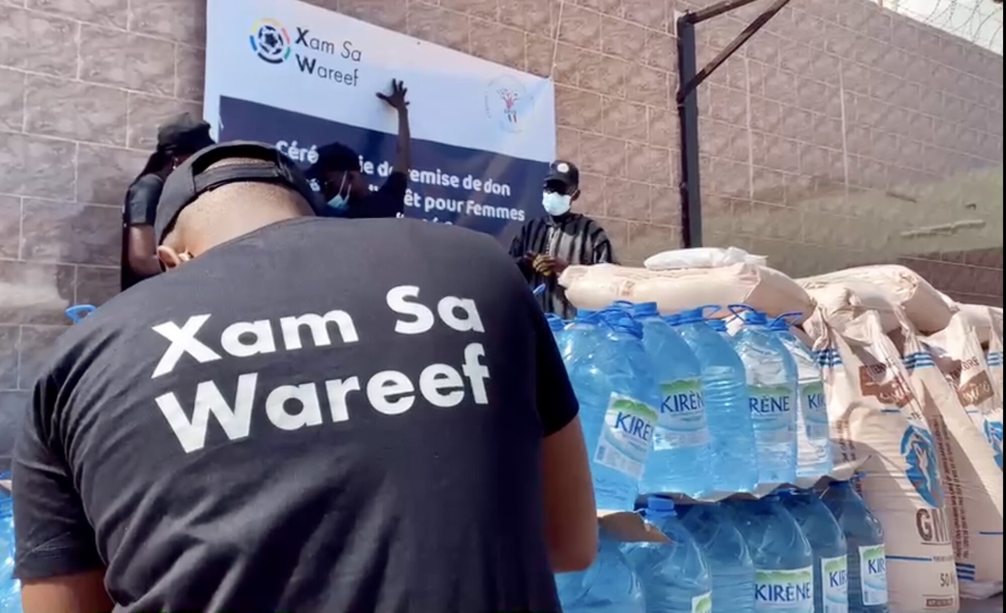 Packs d'eau et sacs de vivres préparés devant la banderole de l'action du 9 avril 2021